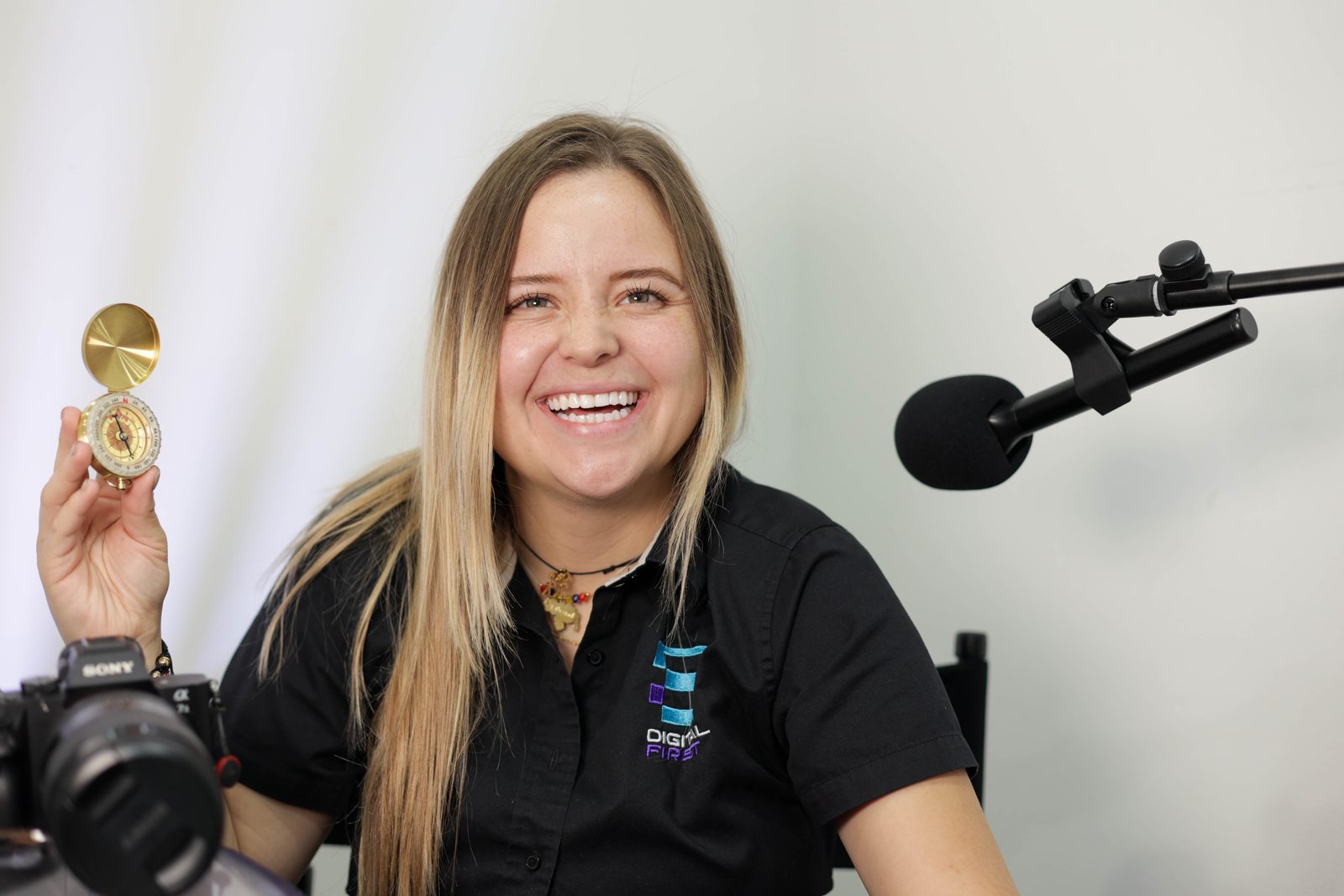 Mafer riendo mientras sostiene en alto la brújula de latón abierta en su estudio