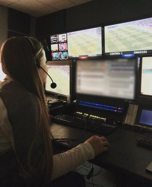 Mafer con audífonos operando gráficos en vivo frente a los monitores de un partido