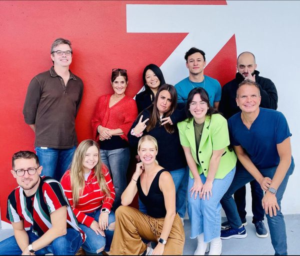 Mafer con el equipo de Zimmerman Advertising frente al mural de la agencia