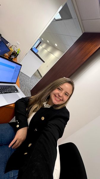 Mafer en la oficina, sonriendo junto a su computadora